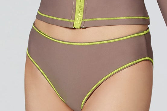 Woman modeling Watskin Sophie cropped jacket and Belle bikini brief in Taupe with neon piping.