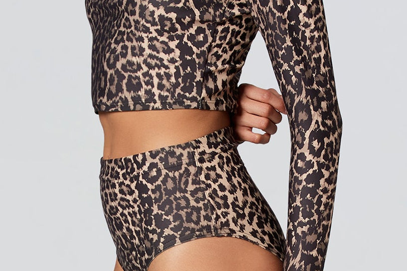 Side facing female model wearing Watskin Clara top and Aria swim bottom in Leopard 