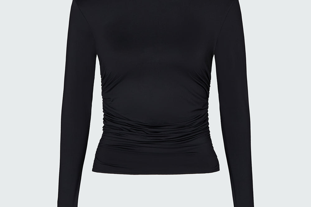 A black long-sleeve mock neck top with ruched detailing at the waist.