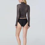 Back view of  woman wearing a long-sleeve mock neck rashguard in leopard and black bikini bottom