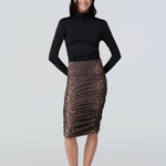Front view of a woman wearing a black turtelneck adn leopard print midi skirt with side ruching.