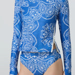 Woman wearing a long sleeve top and bikini bottom in a blue and white bandana print.