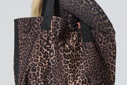 woman carrying a leopard print tote bag