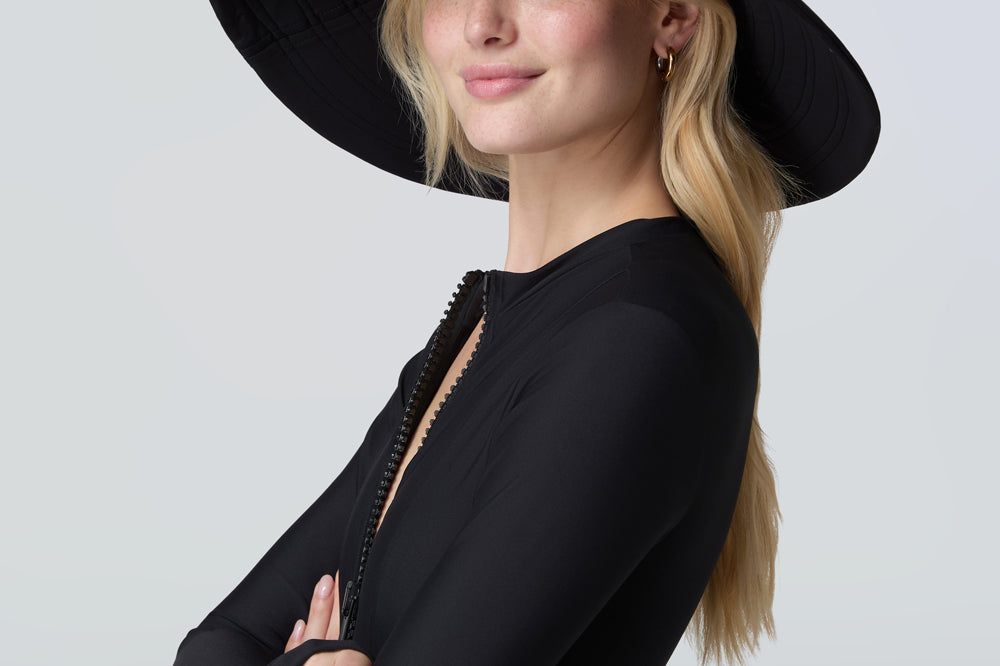 Woman wearing a black sun hat and black bodysuit