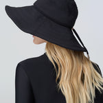 Woman wearing a black sun hat and black bodysuit