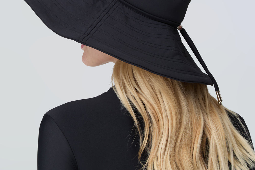 Woman wearing a black sun hat and black bodysuit