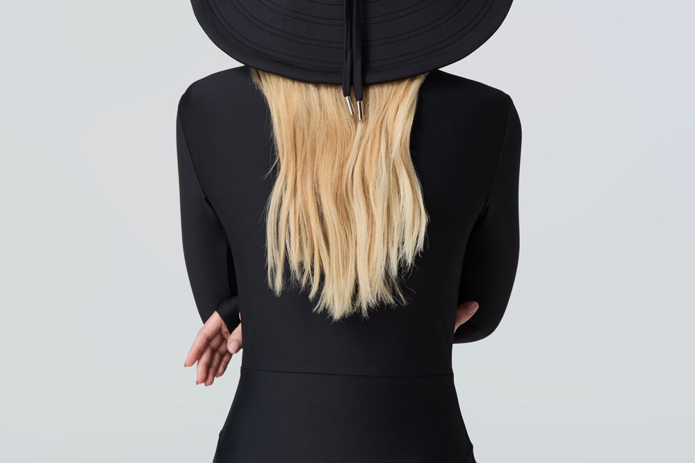 Woman wearing a black sun hat and black bodysuit