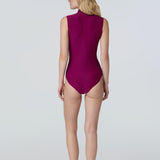 Back view of a woman wearing a sleeveless bodysuit in dark berry with pink zipper.