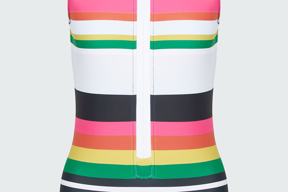 Brightly colored striped sleeveless swimsuit with an oversized white zipper on a light gray background