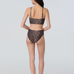 Back view of a woman wearing a leopard print swim and sun protective bralette and bikini bottom.
