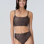 Front view of a woman wearing a leopard print swim and sun protective bralette and bikini bottom.
