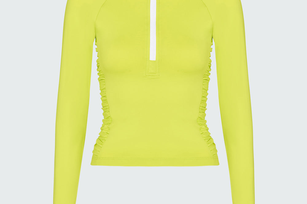 A lime green long-sleeve 1/2 zip rashguard with side ruching