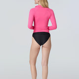 Back view of a woman wearing a pink long-sleeve rashguard with side ruching