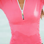 Close up of a long-sleeve 1/2 zip rashguard with side ruching in pink