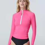 Front view of a woman wearing a bright lime green long-sleeve 1/2 zip rashguard with side ruching
