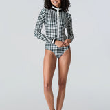 Woman wearing Watskin Lilia bodysuit in black/ivory houndstooth against a gray background