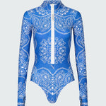 A long-sleeve bodysuit in a blue bandana print with white front zipper.