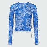 A blue long-sleeve top in a blue and white  bandana-print with side zipper.