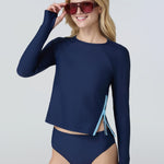Front view of a woman wearing a navy blue long-sleeve top with a light blue side zipper and navy blue bikini bottom.