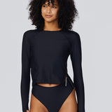 Model wearing Watskin Sasha long sleeve rash guard tee and high cut Belle bikini brief in Black