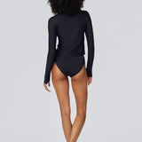Back view of model wearing Watskin Sasha long sleeve rash guard tee and high cut Belle bikini brief in Black