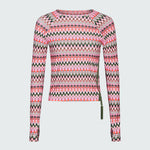 Product flat of a pink and green wavy striped patterned long sleeve swim top on a white background