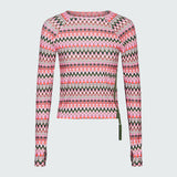 Product flat of a pink and green wavy striped patterned long sleeve swim top on a white background