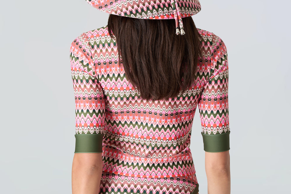 Back view: pink & green wavy stripe wide-brim hat, short-sleeve swim top, bikini bottom