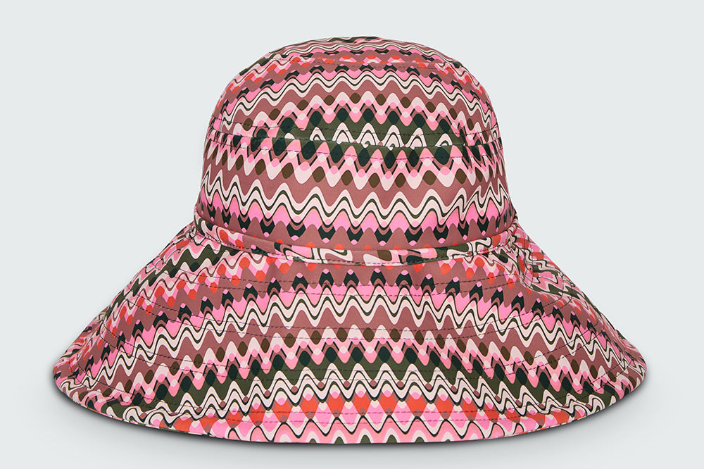Pink and green wavy striped patterned wide brimmed sun hat on a white background