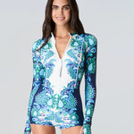 Woman wearing a blue floral swimsuit on a gray background