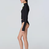 Side view of a woman wearing long sleeve mock neck zip front black rashguard with a yellow zipper and black bikini bottom.