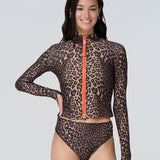 Front view of a woman wearing a long sleeve leopard print zip front rashguard and bikini bottom.