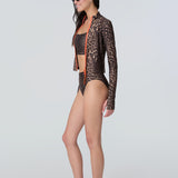 Side view of a woman wearing a long sleeve leopard print zip front rashguard, bralette, and bikini bottom.